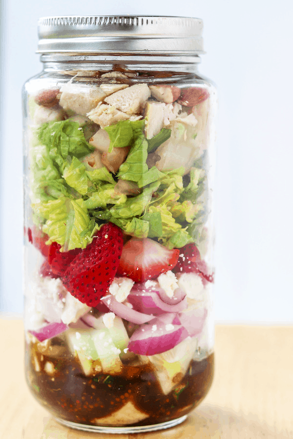 Strawberry avocado summer salad with chicken- featuring a crunchy romaine, cucumber, red onion, chopped nuts and pungent cheese then tossed in honey basil vinaigrette makes for the ultimate summer salad combo that will leave you feeling satisfied #avocado #strawberries #salad #summersalad #mealprep #masonjarsalad | Mealswithmaggie.com