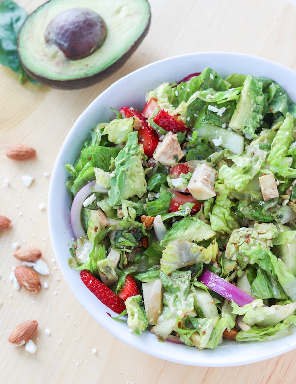 Strawberry avocado summer salad with chicken- featuring a crunchy romaine, cucumber, red onion, chopped nuts and pungent cheese then tossed in honey basil vinaigrette makes for the ultimate summer salad combo that will leave you feeling satisfied #avocado #strawberries #salad #summersalad #mealprep #masonjarsalad | Mealswithmaggie.com