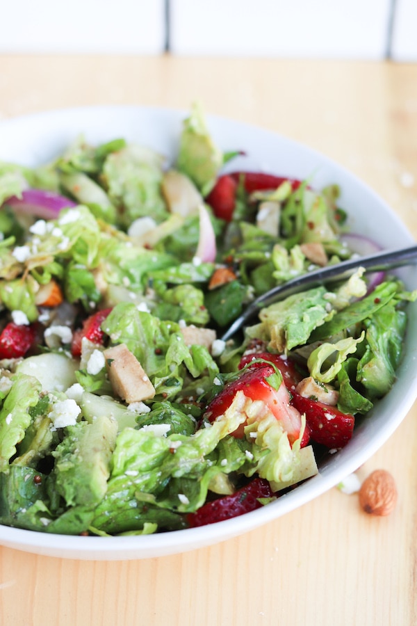 Strawberry avocado summer salad with chicken- featuring a crunchy romaine, cucumber, red onion, chopped nuts and pungent cheese then tossed in honey basil vinaigrette makes for the ultimate summer salad combo that will leave you feeling satisfied #avocado #strawberries #salad #summersalad #mealprep #masonjarsalad | Mealswithmaggie.com