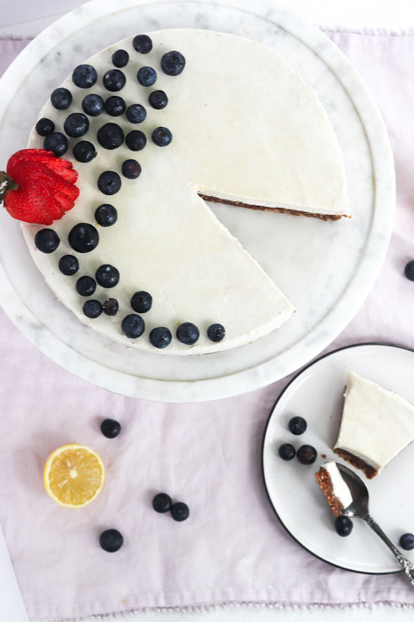 cheesecake on a plate with a spoon and a slice taken out.