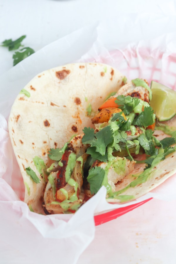 These one sheet pan chicken fajitas with avocado sauce can be made in under 30 minutes and is an easy clean up! Peppers, avocado and low sodium fajita seasoning makes for a heart healthy meal. | mealswithmaggie.com #hearthealthy #onesheetpandinner #onesheetpanchickenfajitas #avocadosauce #lowsodiumfajitas #quickandeasydinner #mealprep