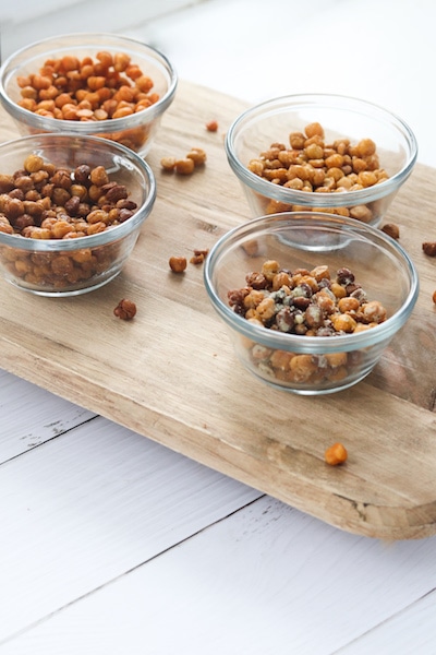 Roasted chickpeas seasoned 4 ways is a great snack under 100 calories a serving and provides about 4 grams of fiber and protein in a serving! They are easy to prepare and can be used in soups, salads, pasta or rice dishes or eaten straight from the oven. | mealswithmaggie.com #5ingredientsorless #roastedchickpeas #crunchy #easymealprep #easysnackidea #lowcaloriesnack #highproteinsnack #highfibersnack