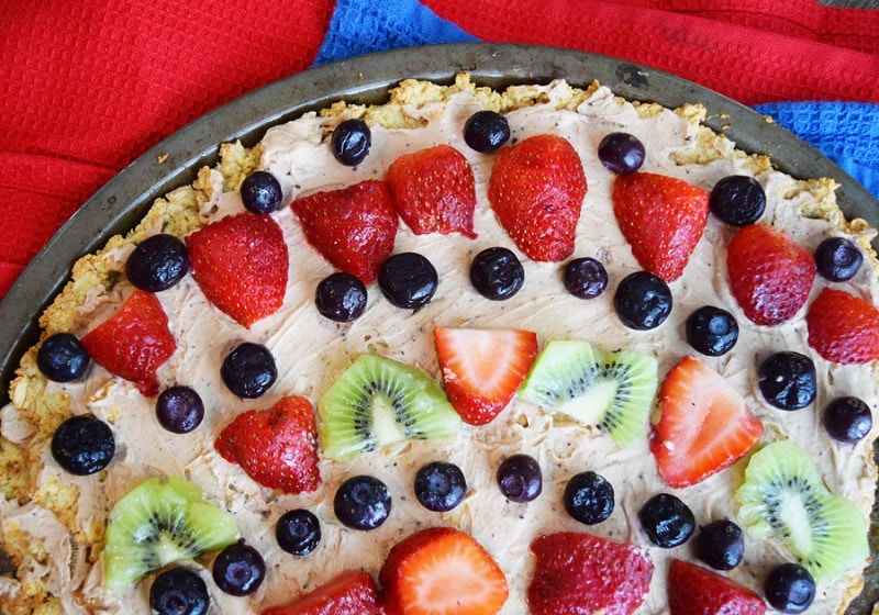 fruit pizza on a plate with frosting.