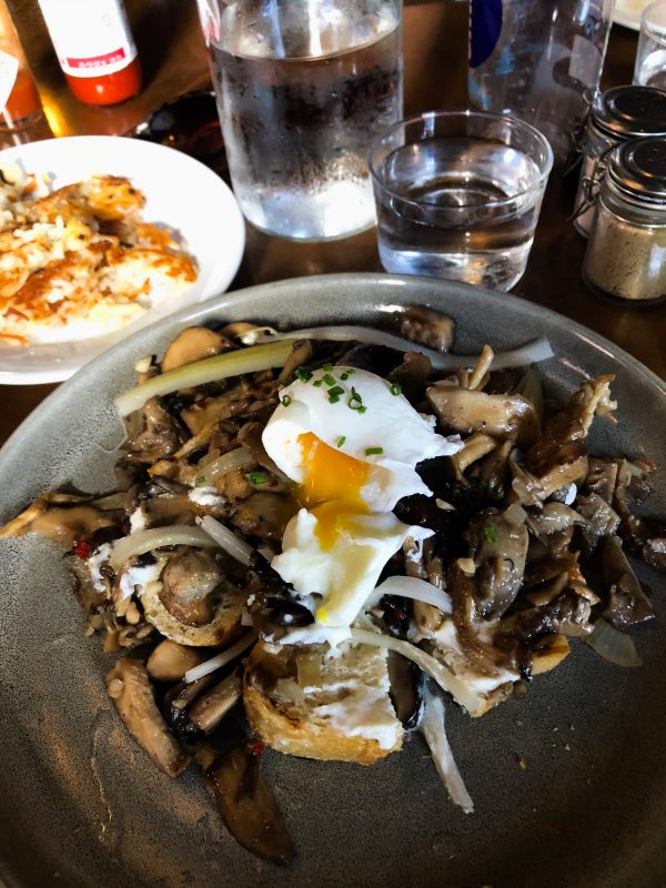 breakfast food on a plate with a runny egg.