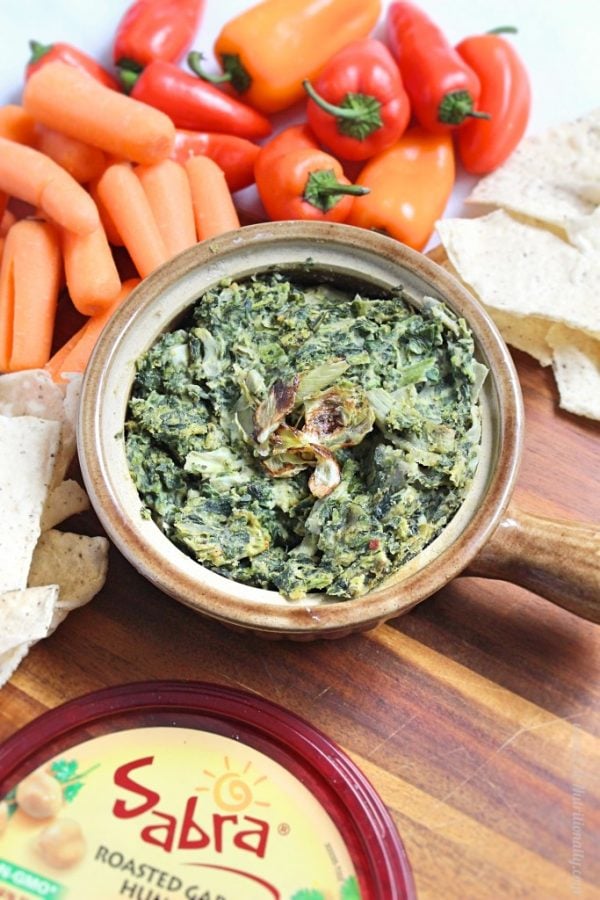 spinach dip in a crock with vegetables.