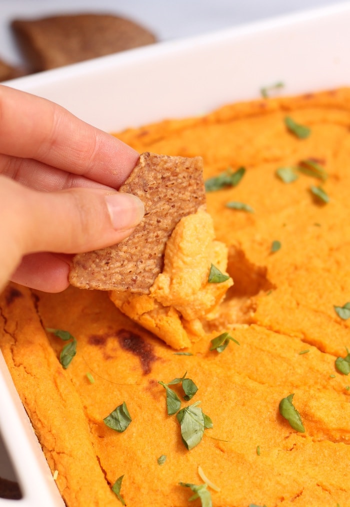 a hand dipping buffalo dip.