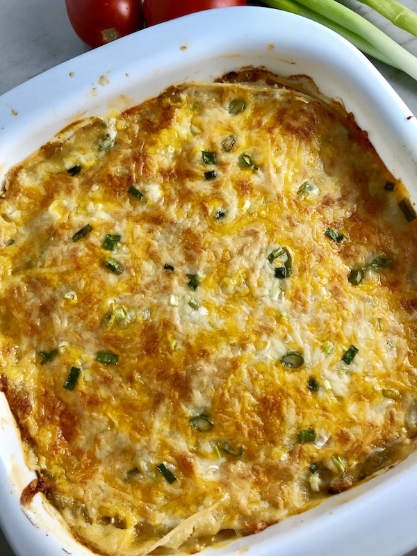cheesy dip with green onions in a casserole dish
